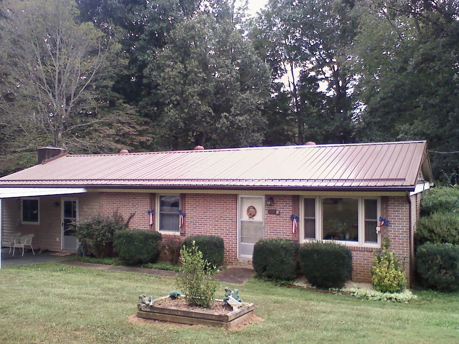 Bronze metal roof on a brick ranch home with a carport in Santa Ana