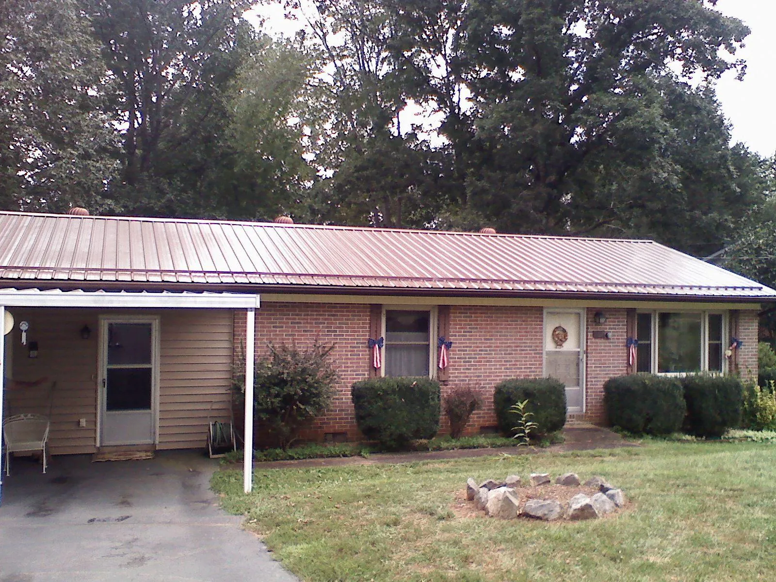 Bronze metal roof and carport on a brick ranch home — Roof Repair work by our crew in Santa Ana